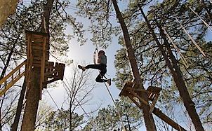 Child swinging through ropes course